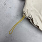 Reebok Windbreaker creme gelber Kordelzug am Saum Detail
