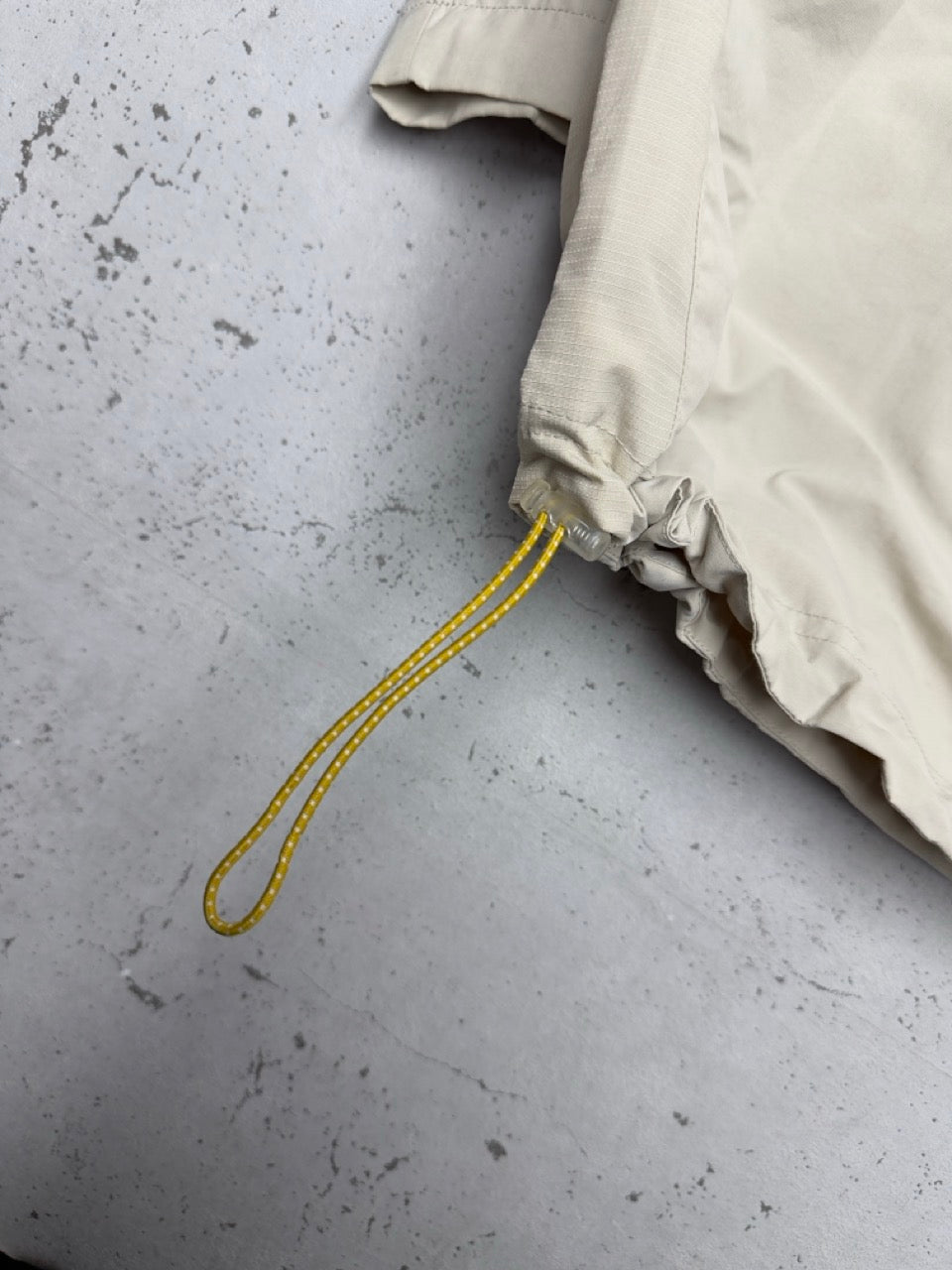 Reebok Windbreaker creme gelber Kordelzug am Saum Detail