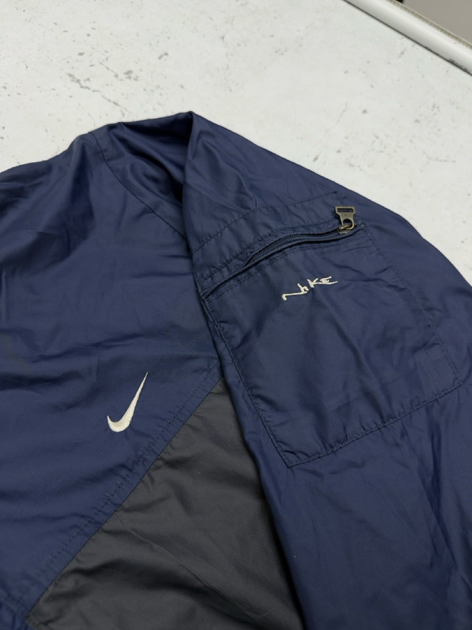 Nike Nylonjacke navy anthrazit Ärmeltasche mit Nike Schriftzug Detail