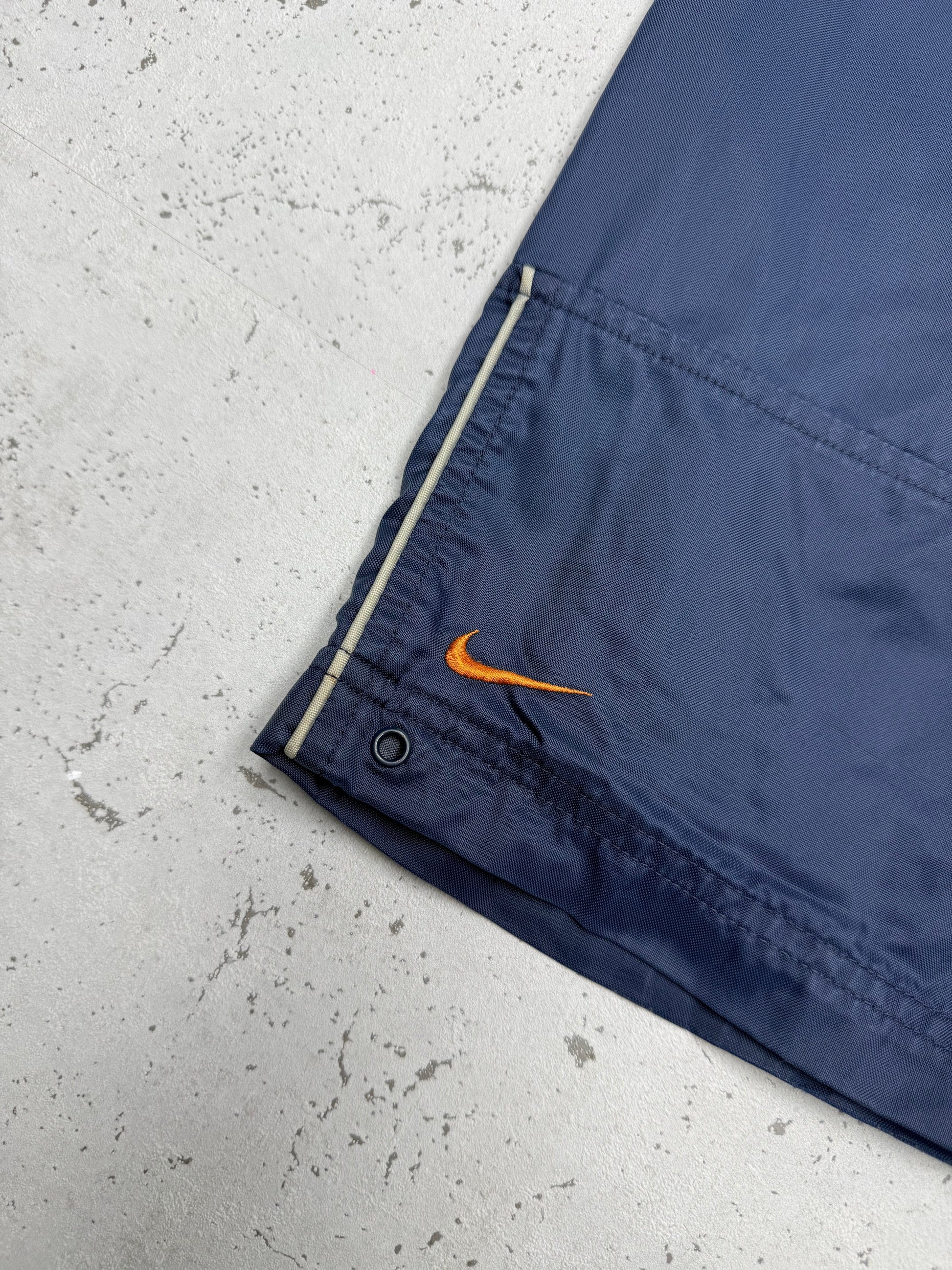 Nike Vintage Cargo Trackpants in Navy mit orangem Swoosh, Größe L, Swoosh am Saum Nahaufnahme