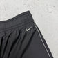Nike Vintage Trackpants in Schwarz mit weißer Paspel, Größe M, Swoosh-Logo Nahaufnahme