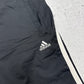 adidas Vintage Trackpants in Schwarz, Detailaufnahme des gestickten adidas Logos