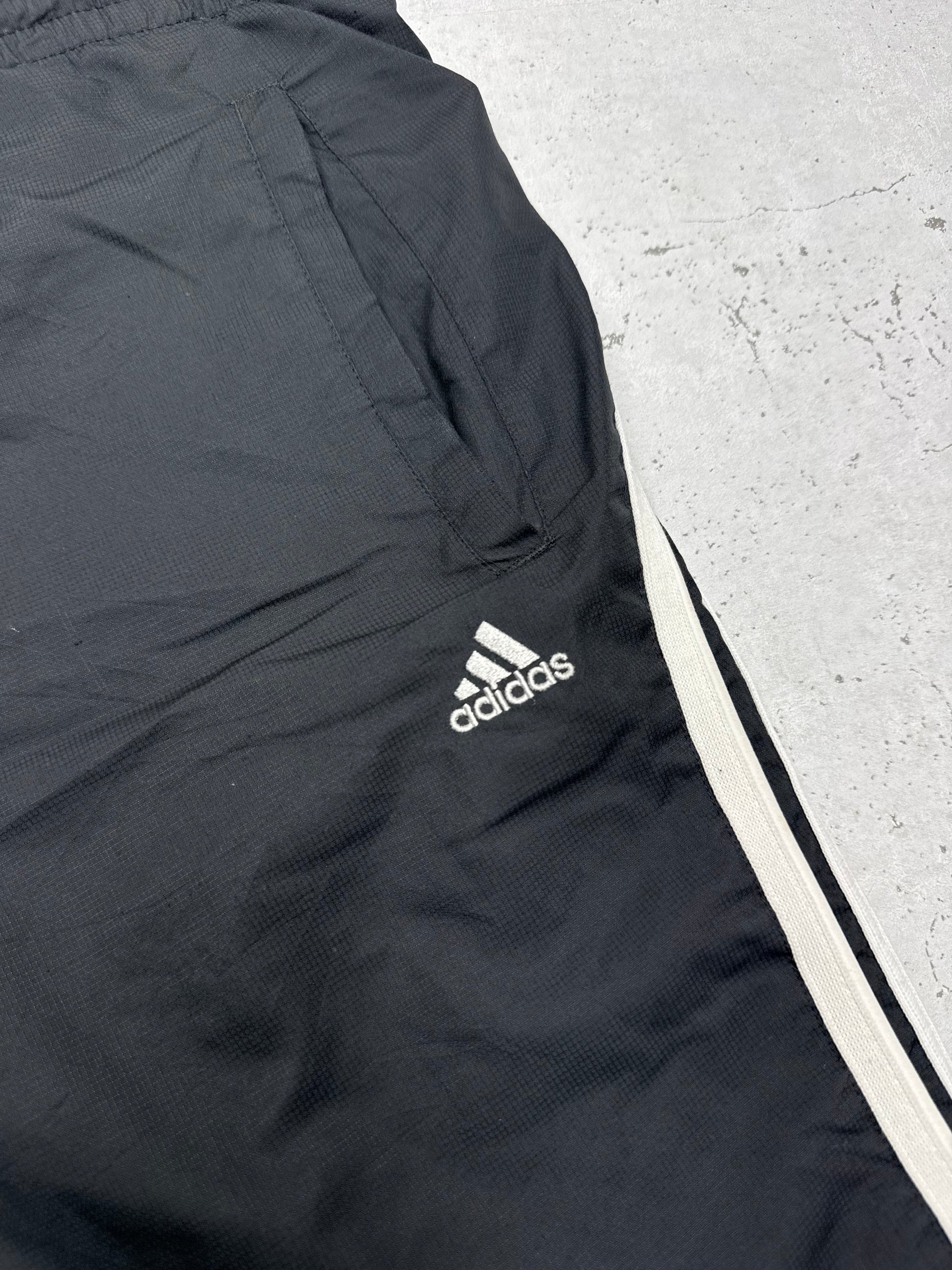 adidas Vintage Trackpants in Schwarz, Detailaufnahme des gestickten adidas Logos