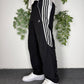 adidas Vintage Trackpants in Schwarz mit drei weißen Streifen, Größe XS, am Model getragen