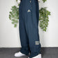 adidas Vintage Trackpants in Navy mit goldenem Logo, Groesse XL, getragen am Model